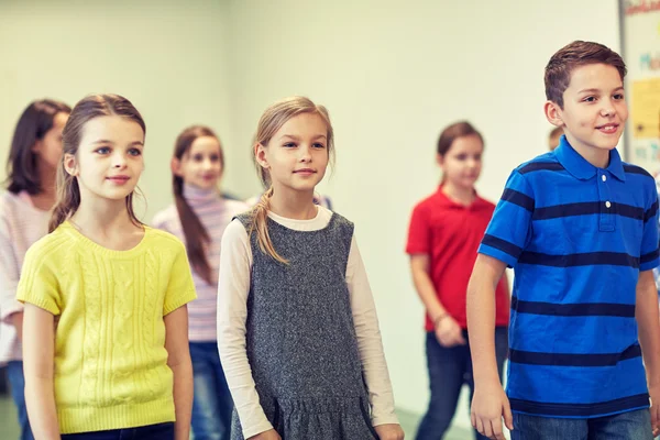 Grupp av leende skola barn gå i korridoren — Stockfoto