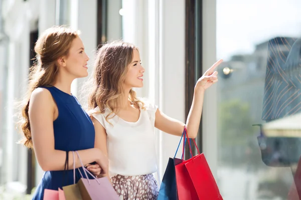 Donne felici con le borse della spesa alla vetrina — Foto Stock