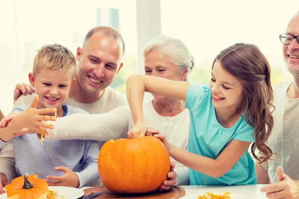 Família feliz sentado com abóboras em casa — Fotografia de Stock