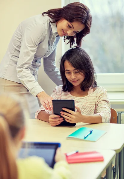Liten flicka med lärare och tablet pc i skolan — Stockfoto