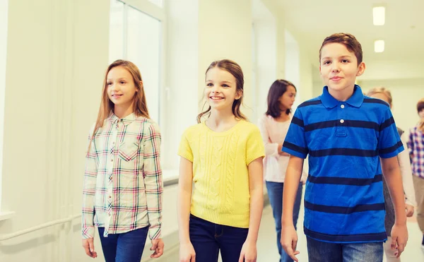 Groupe d'écoliers souriants marchant dans le couloir — Photo