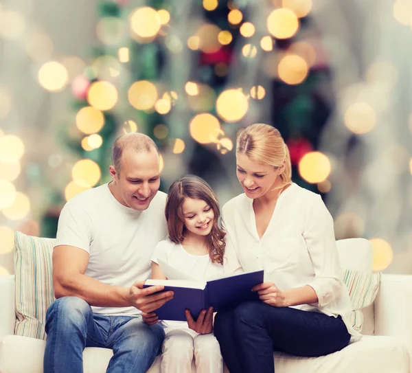 Famiglia felice con libro a casa — Foto Stock