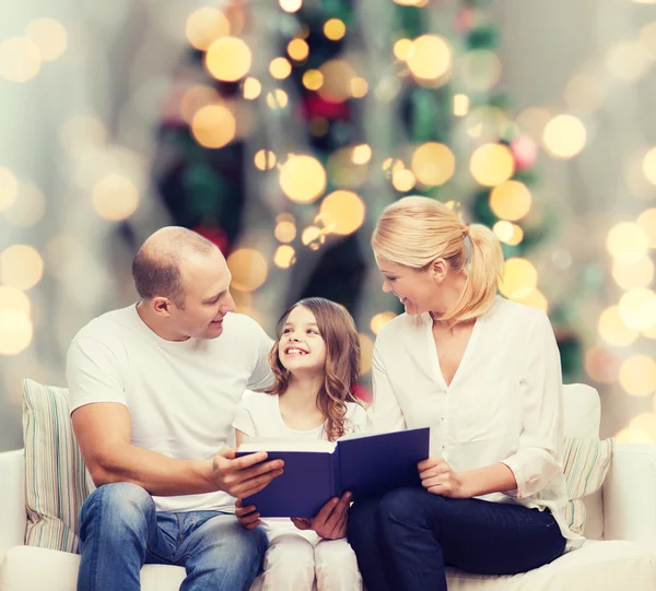 Famiglia felice con libro a casa — Foto Stock