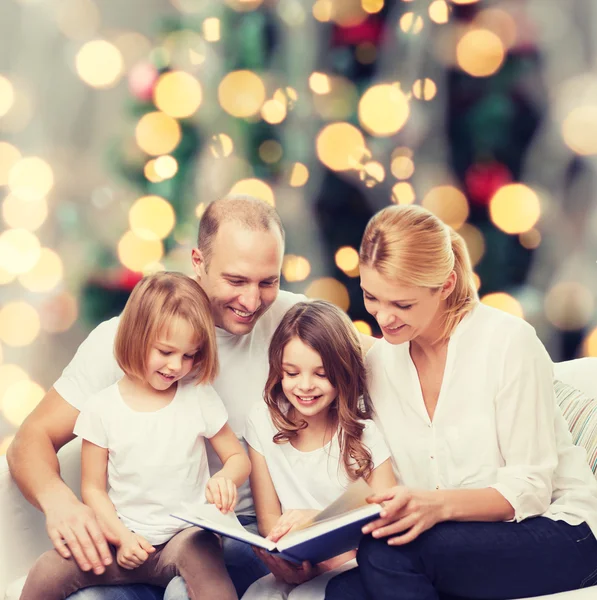 Familia feliz con libro en casa — Foto de Stock