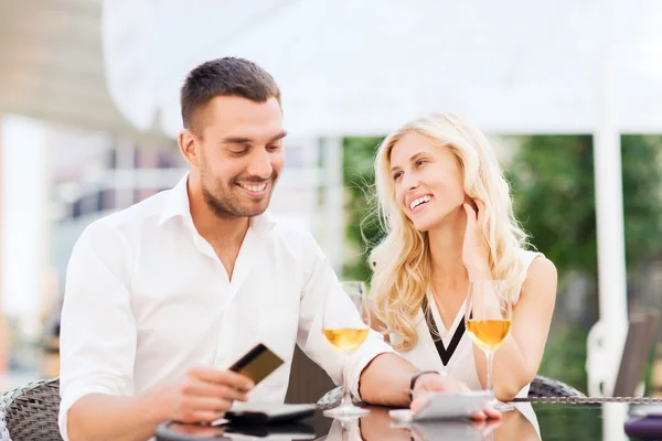 Счастливая пара с банковской картой и счет в ресторане — стоковое фото
