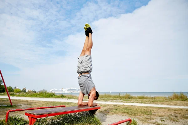 Joven haciendo ejercicio en el banco al aire libre —  Fotos de Stock