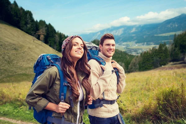 Casal sorrindo com mochilas caminhadas — Fotografia de Stock