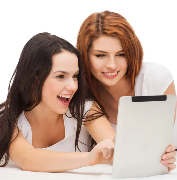 Дві усміхнені дівчата-підлітки з планшетним комп'ютером — стокове фото