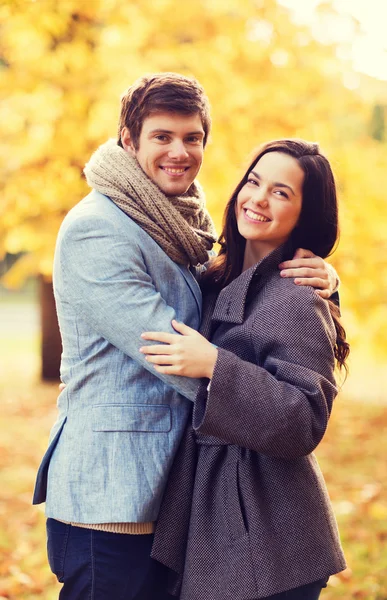 Couple souriant étreignant dans le parc d'automne — Photo