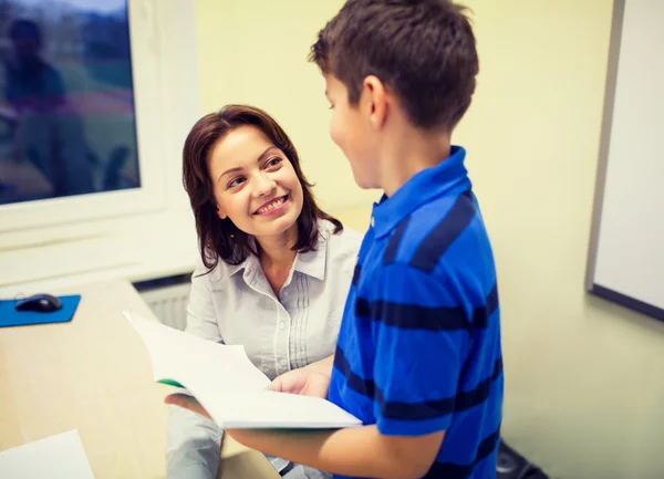 School jongen met notebook en leraar in de klas — Stockfoto