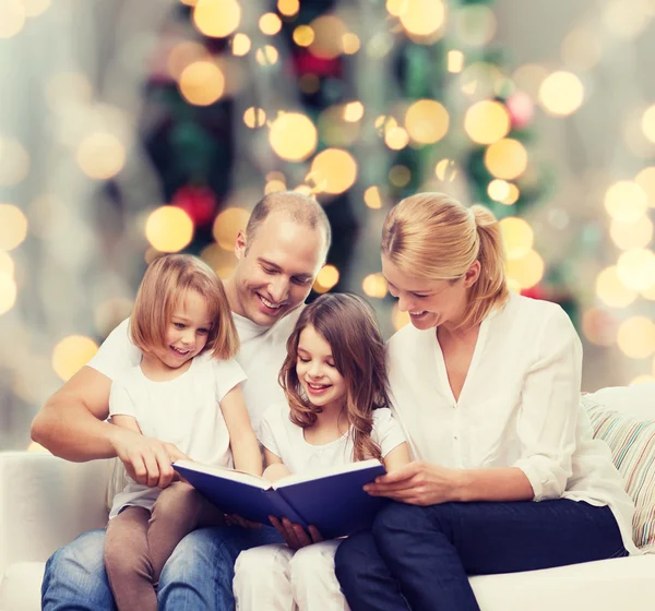 Gelukkige familie met boek thuis Stockfoto