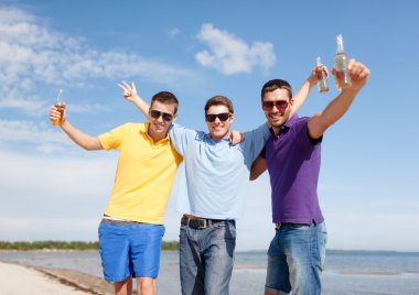 happy friends with beer bottles on beach clipart