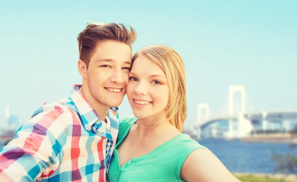 Hymyilevä pari ottaa selfie sillan yli — kuvapankkivalokuva