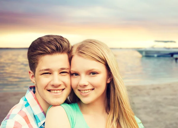 Lachende paar knuffelen over beach achtergrond — Stockfoto