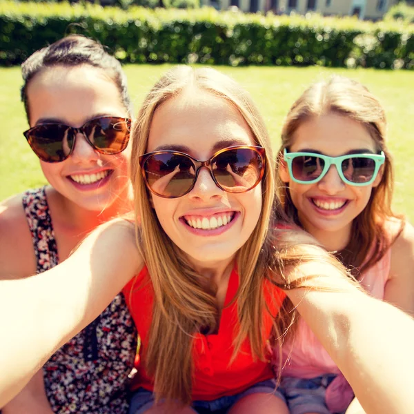 Grupa uśmiechniętych dziewczyn nastolatek biorąc selfie w parku — Zdjęcie stockowe