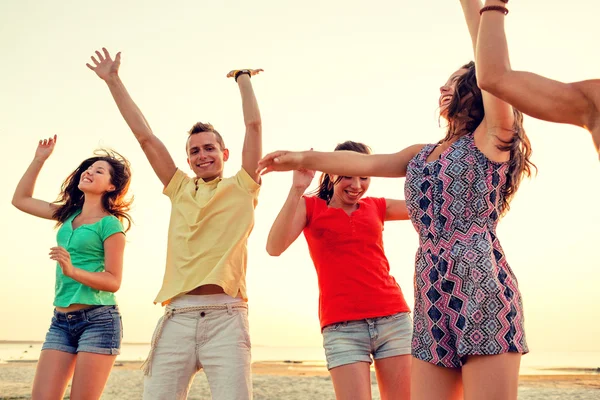 Τους φίλους χαμογελώντας χορεύουν στην παραλία το καλοκαίρι — Φωτογραφία Αρχείου
