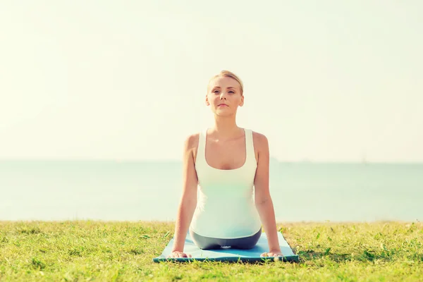 Yoga egzersizleri yaparak genç bir kadın — Stok fotoğraf