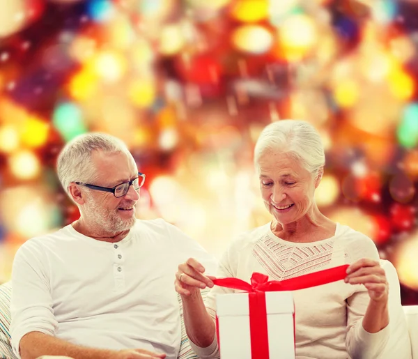 Glückliches Seniorenpaar mit Geschenkbox zu Hause — Stockfoto