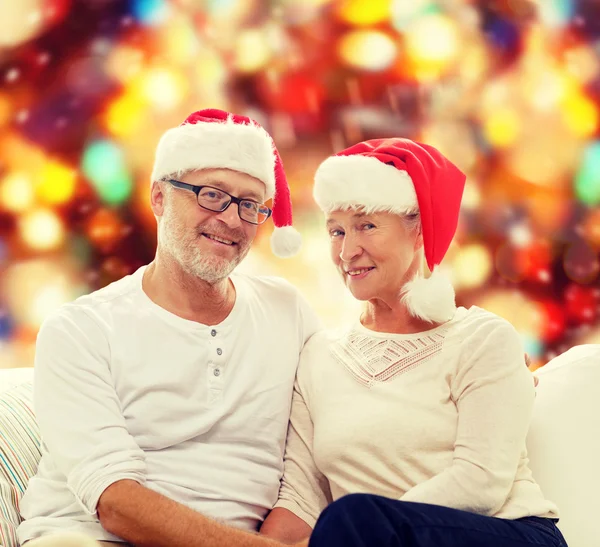 Happy senior couple in santa helper hats — Stock Photo, Image