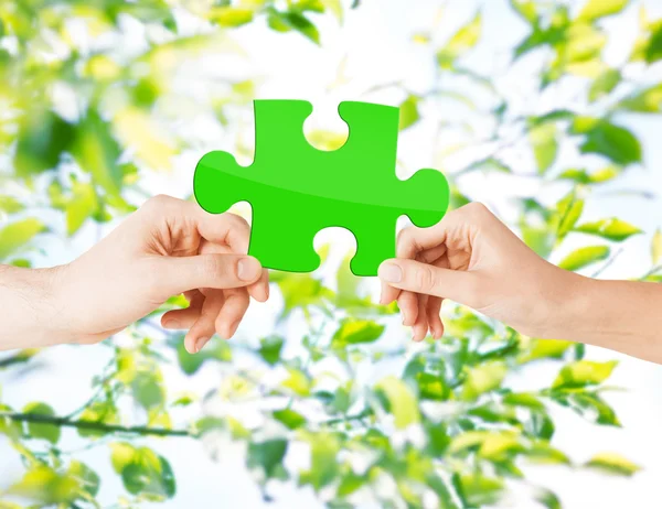 Mains avec puzzle vert sur fond naturel — Photo