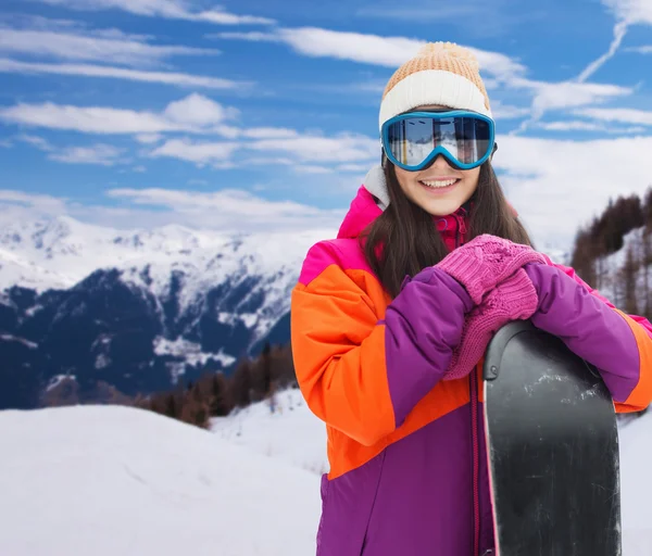 Glad ung kvinna med snowboard över bergen — Stockfoto