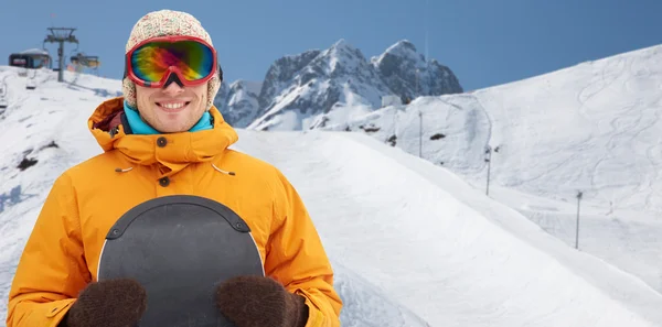 Happy young man in ski goggles over mountains — Stock Photo, Image