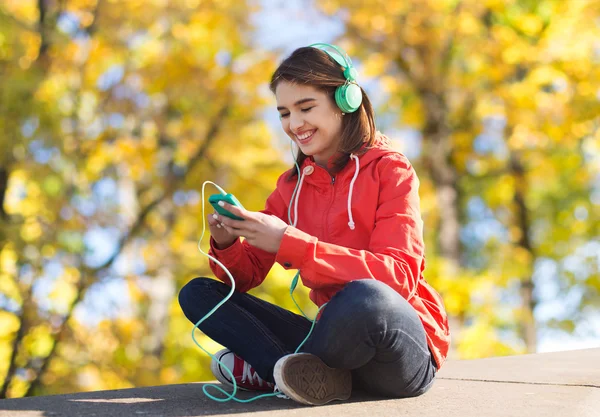 Szczęśliwa młoda kobieta z smartphone i słuchawki — Zdjęcie stockowe