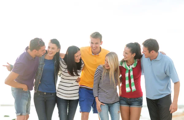 Gruppe glücklicher Freunde unterhält sich am Strand — Stockfoto