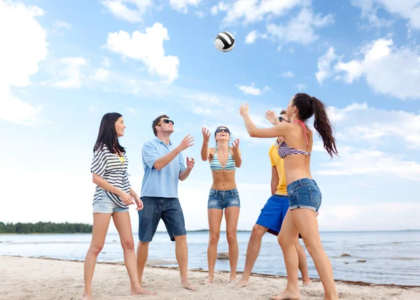 Groep gelukkige vrienden spelen strandbal — Stockfoto