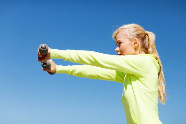 Sportieve vrouw met lichte halters buitenshuis — Stockfoto