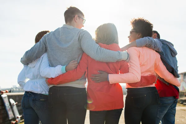 Groep van gelukkig jeugdvrienden knuffelen op straat — Stockfoto