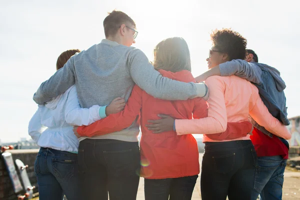 Groupe d'amis adolescents heureux étreignant dans la rue — Photo