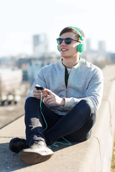 Jovem feliz em fones de ouvido com smartphone — Fotografia de Stock