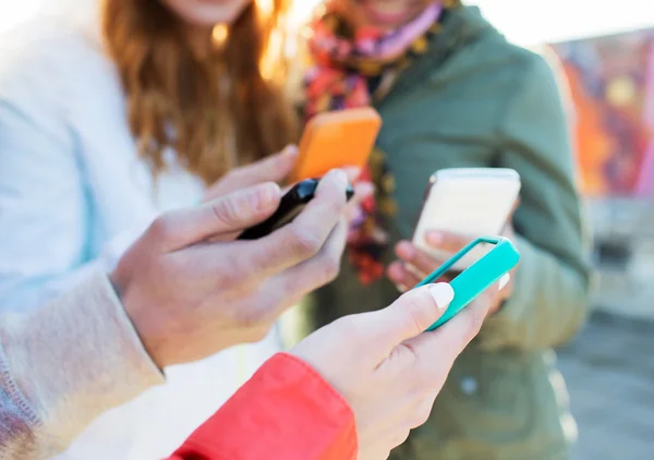 Primer plano de amigos con teléfonos inteligentes al aire libre — Foto de Stock