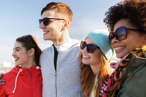Happy teenage friends in shades hugging outdoors — Stock Photo, Image