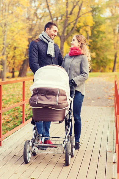 Bebek arabası sonbahar Park ile gülümseyen Çift Stok Fotoğraf