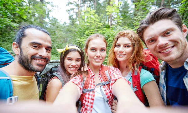 Amigos com mochila tomando selfie em madeira — Fotografia de Stock