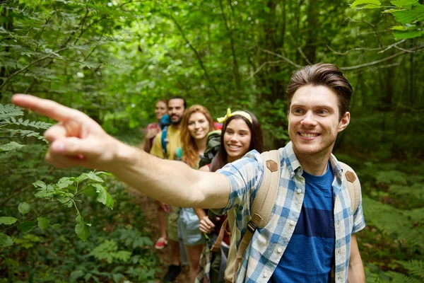 Groep lachende vrienden met rugzakken wandelen — Stockfoto