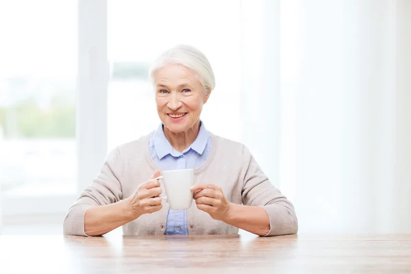 Щаслива старша жінка з чашкою чаю або кави — стокове фото
