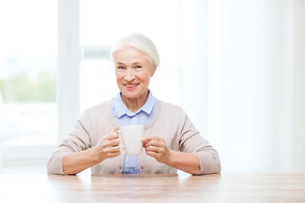 Felice donna anziana con tazza di tè o caffè — Foto Stock