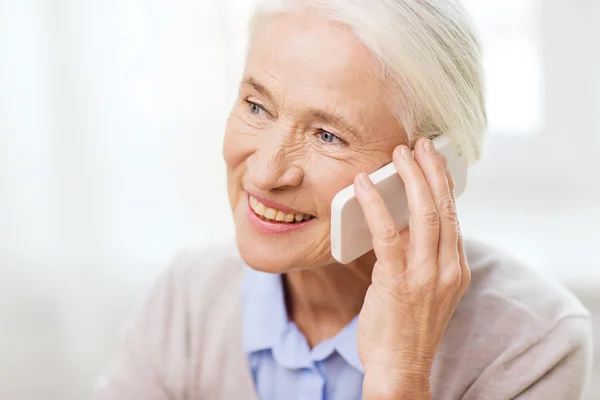Пожилая женщина со смартфоном звонит домой — стоковое фото