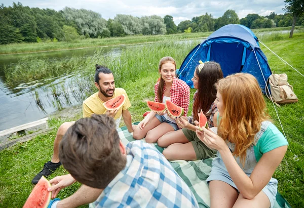 Amigos felices comiendo sandía en el camping —  Fotos de Stock