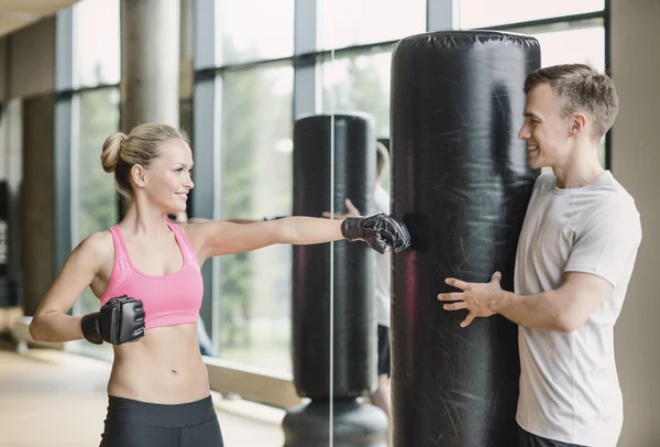 Mujer sonriente con entrenador personal boxeo en el gimnasio —  Fotos de Stock