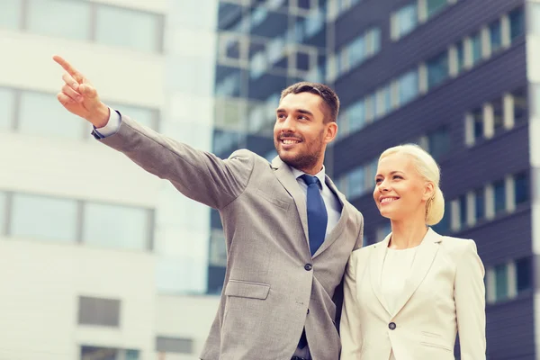 Empresários sorridentes em pé sobre edifício de escritórios — Fotografia de Stock