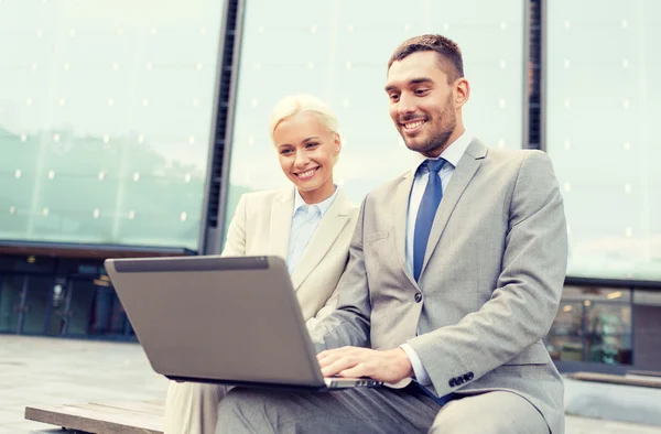 Uomini d'affari sorridenti con computer portatile all'aperto — Foto Stock