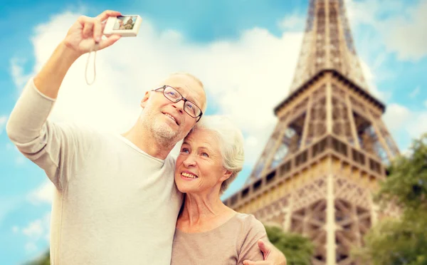 Пожилая пара с камерой над Эйфелевой башней — стоковое фото