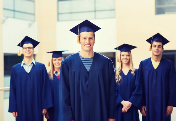 Grupp leende studenter i mortarboards — Stockfoto