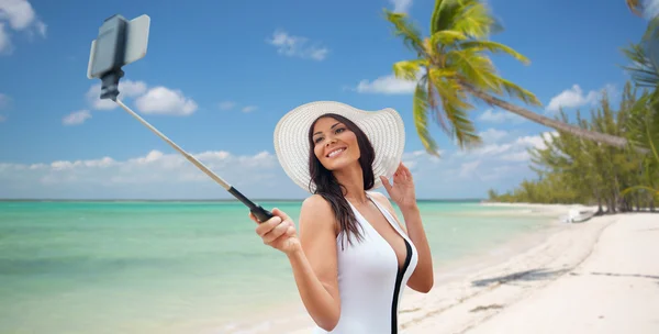 Gelukkige vrouw die selfie met smartphone op strand — Stockfoto