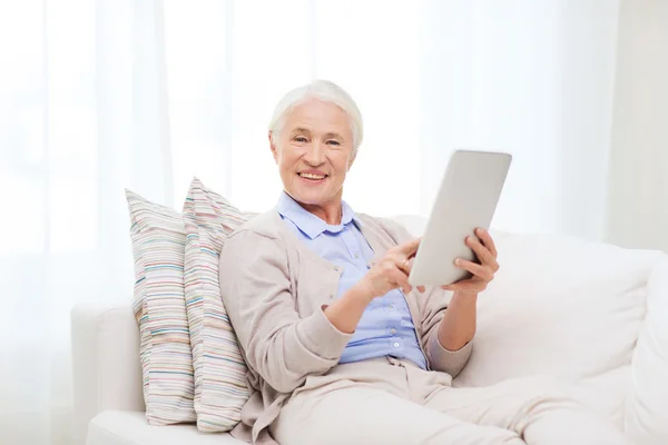 Mulher sênior feliz com tablet pc em casa — Fotografia de Stock