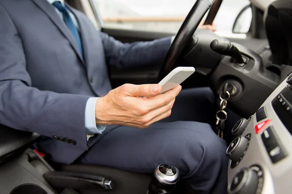 Primer plano del hombre con smartphone coche de conducción —  Fotos de Stock